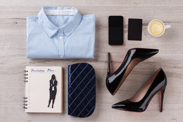 A capsule wardrobe of women's workwear essentials, including a blazer, pencil skirt, trousers, a button-down shirt, and a sheath dress, all in neutral colors. Shoes include pumps, flats, and ankle boots.