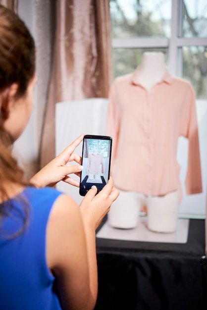 A close-up shot of a smartphone screen displaying a fashion app that uses AI to analyze a user's style preferences and make personalized clothing suggestions. The interface should be clean, modern, and visually appealing.